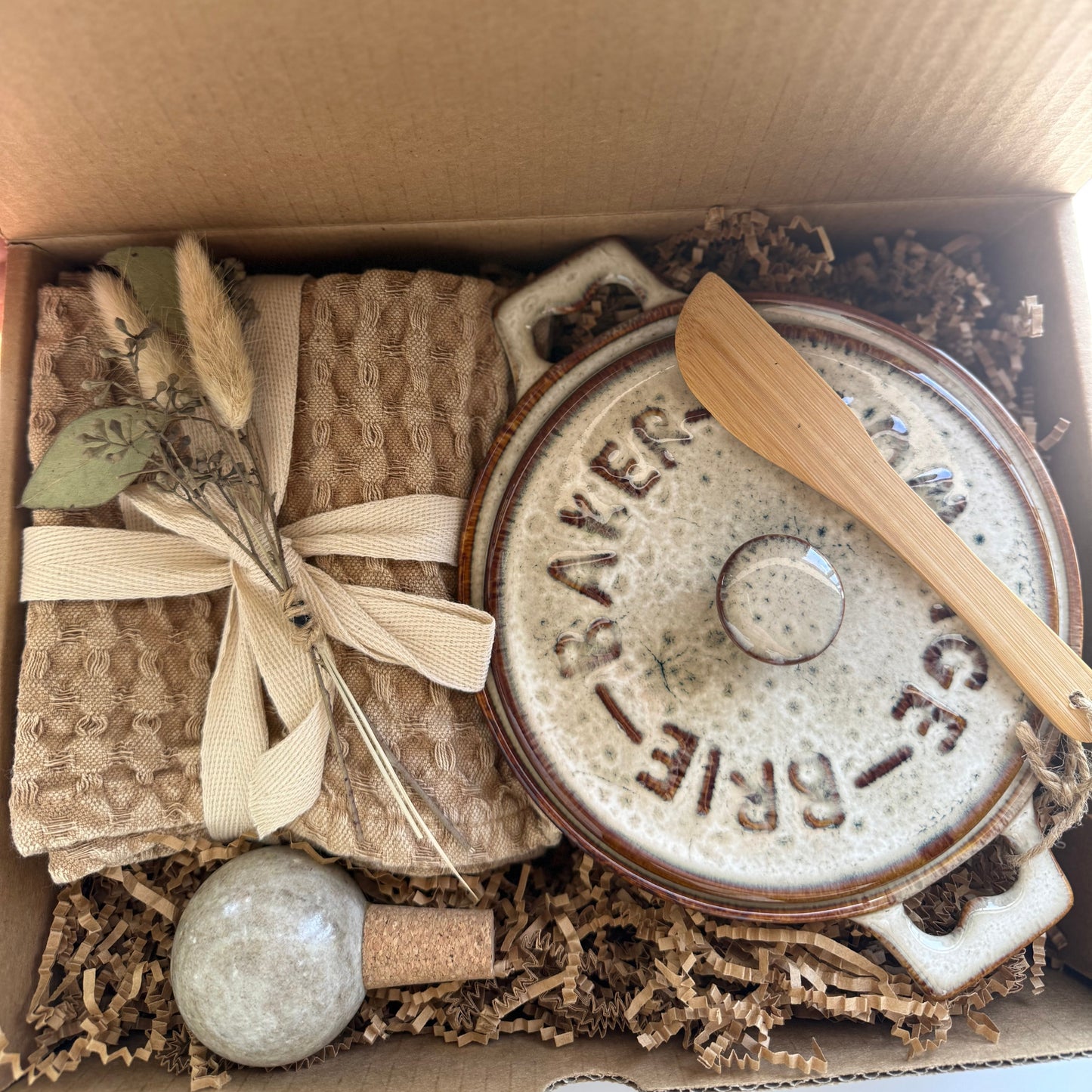 Decorative box with a ceramic pot, wooden spoon, and other items, branded 'The Fox and Pantry'.