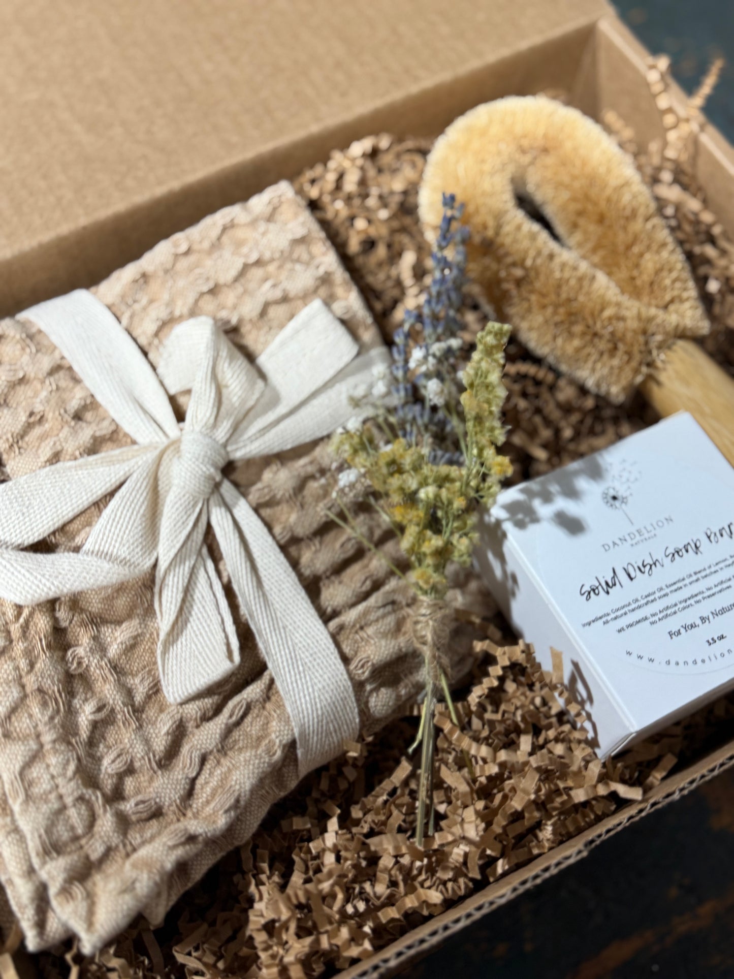 Gift set with textured blanket, bath brush, and soap in a box
