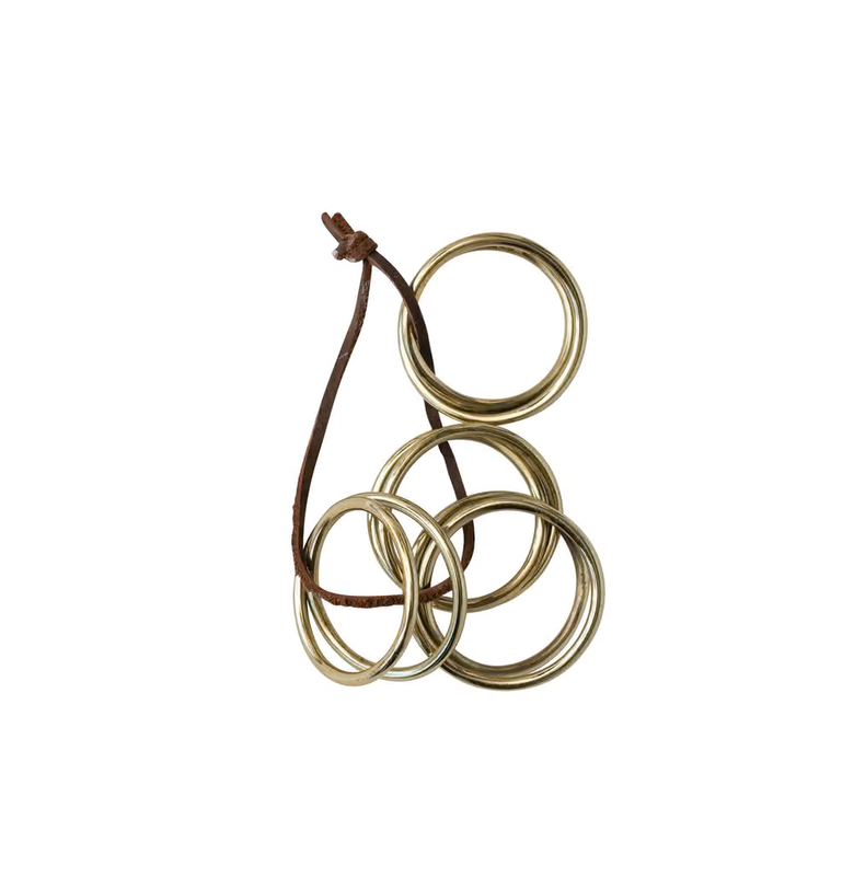 Three metallic rings on a leather cord against a white background