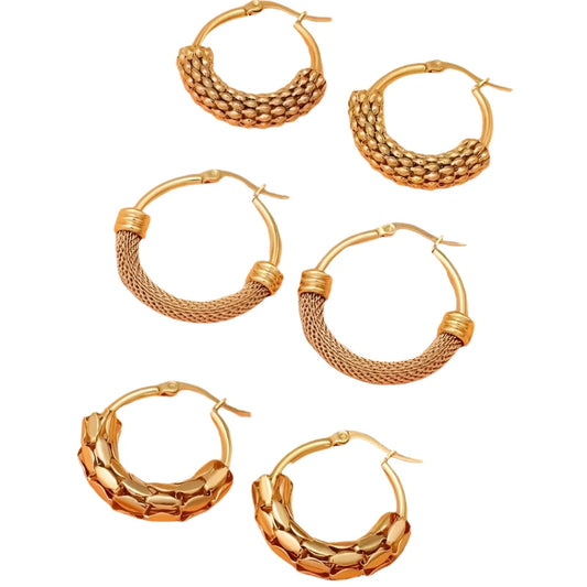 Set of gold hoop earrings on a peach background