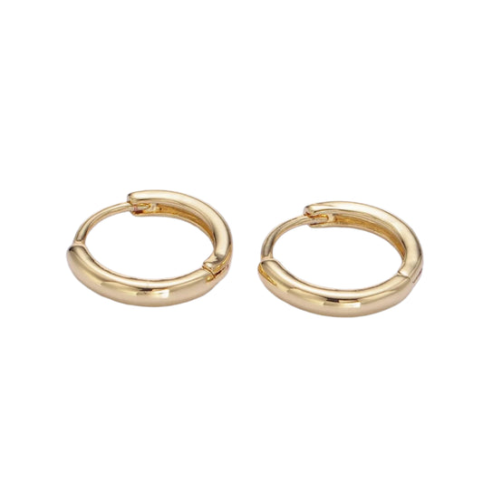 Gold hoop earrings on a light purple background
