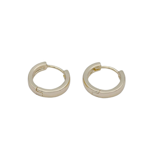 Gold hoop earrings on a light purple background