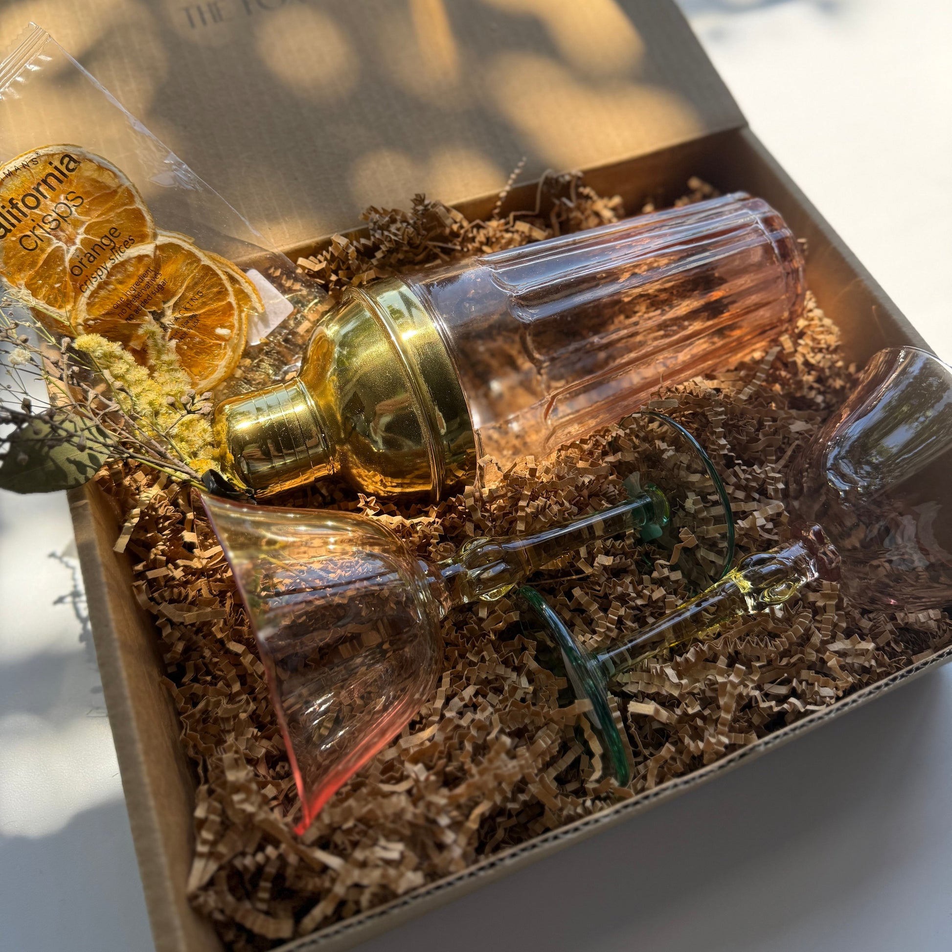 Decorative bottle with gold cap in a box with brown tissue paper