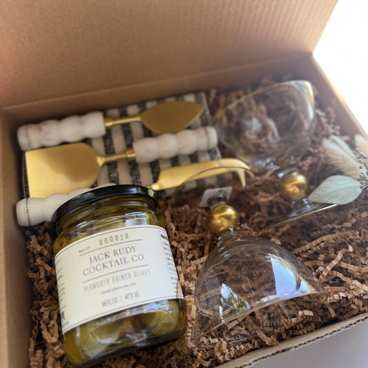 Gift set with cocktail ingredients and tools in a box labeled 'The Fox and Pantry'.