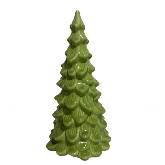 Green ceramic Christmas tree on a white surface with a neutral background