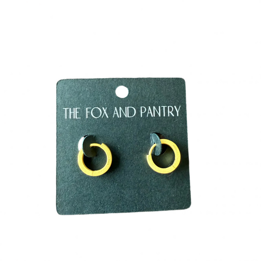 Pair of yellow and black earrings on a 'The Fox and Pantry' branded card, placed on a wooden surface.