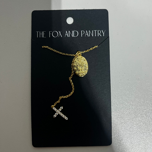 Gold necklace with a pendant on a 'The Fox and Pantry' card against a white background