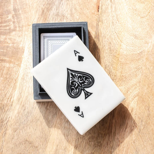 Playing cards with a black spade symbol on a wooden surface