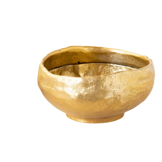 Gold bowl on a light surface with a white background