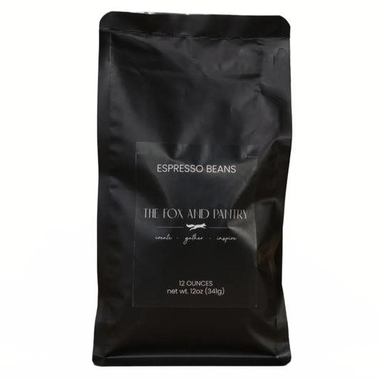 Black bag of espresso beans from The Fox and Pantry on a brown background
