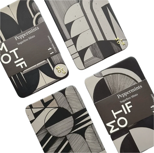 Four black and white patterned tins with 'MOTIF' branding on a light gray background.