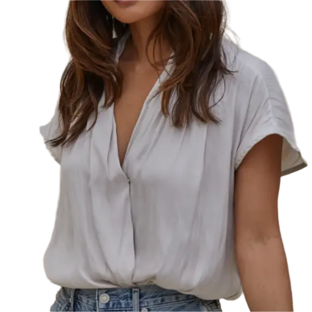 Woman wearing a light gray blouse with a neutral background