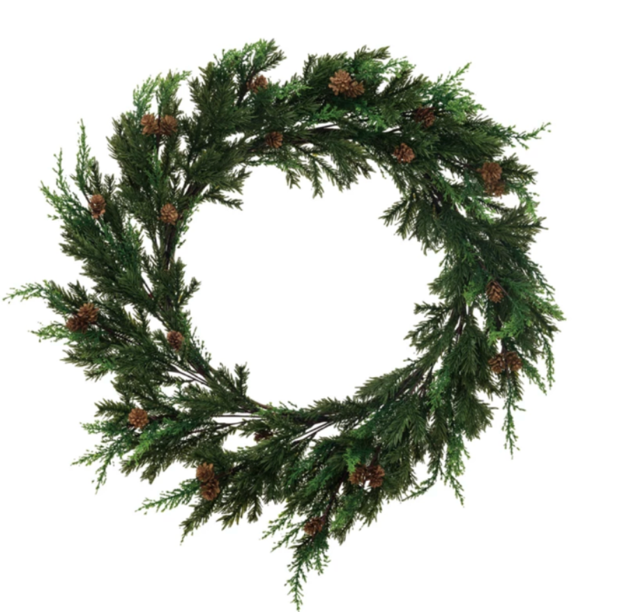 Green artificial wreath with pinecones on a white background