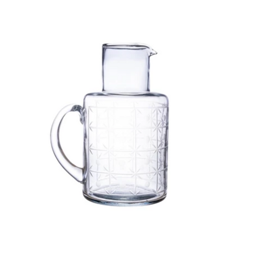 Clear glass carafe with geometric pattern on a white background