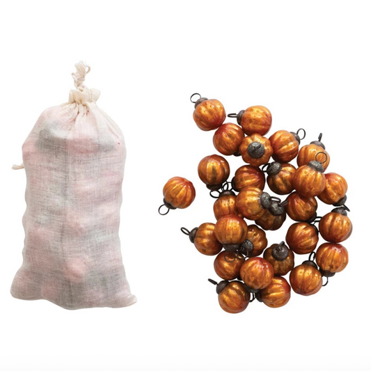 Decorative string of small pumpkins next to a sack on a white background