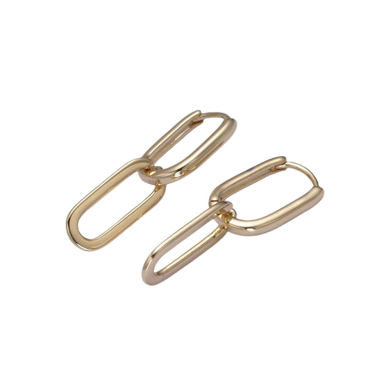 Gold hoop earrings on a light purple background