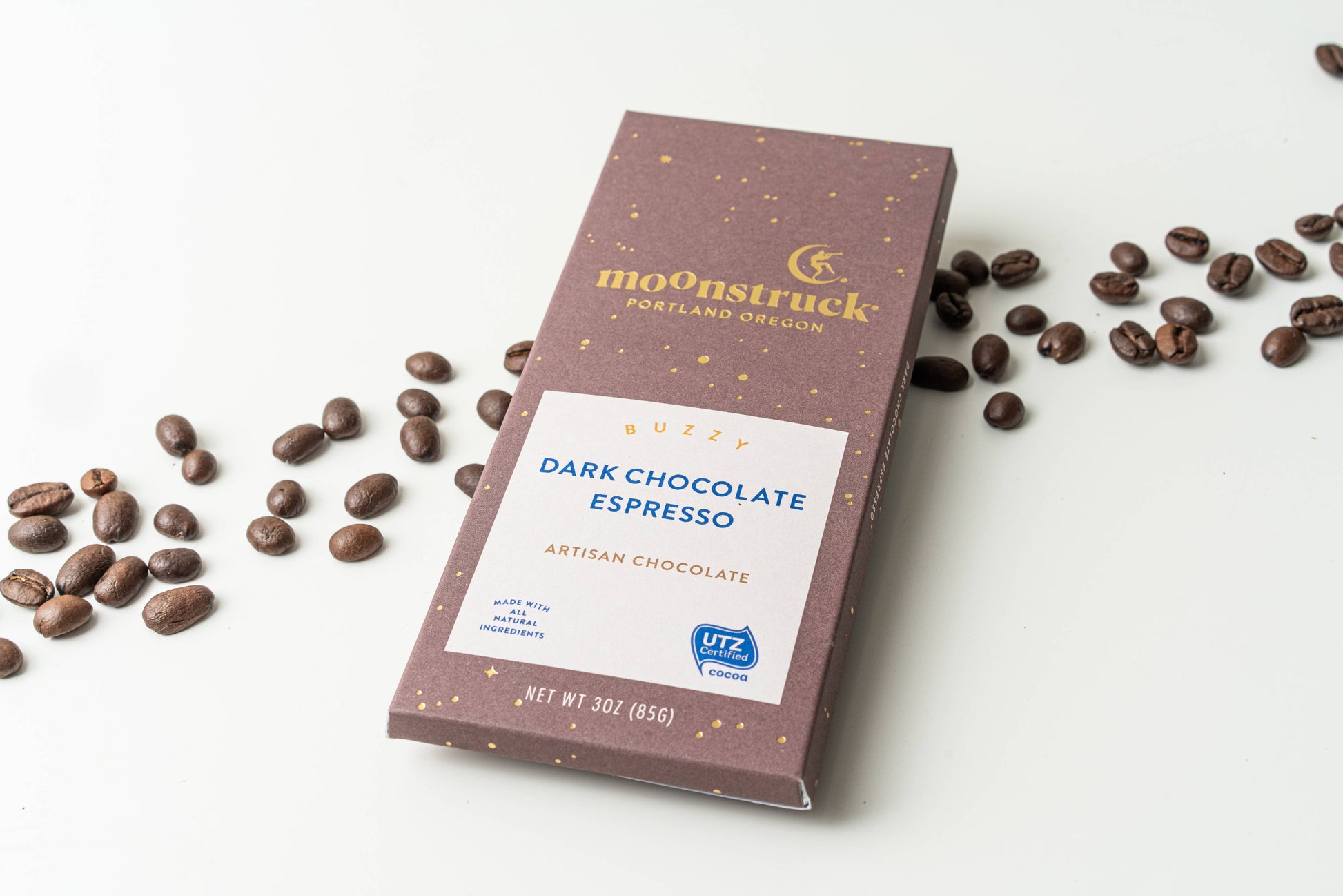 Moonstruck Dark Chocolate Espresso bar with coffee beans on a white background