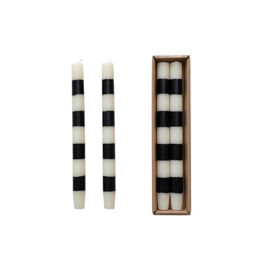 Black and white striped candles with one candle outside the box on a white background